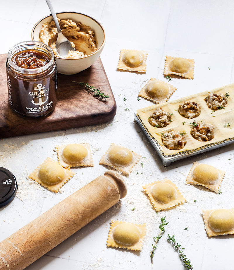 SaltSpring Kitchen Company Onion and Thyme Goat Cheese Ravioli on a table with a jar of preserves