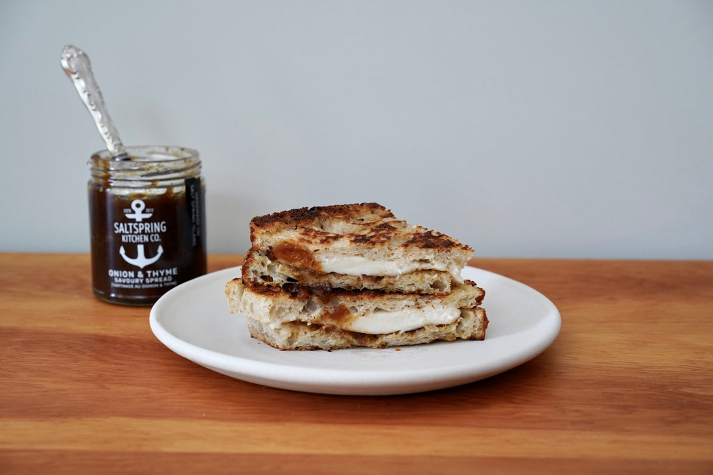 Saltspring Kitchen Company French Onion and Thyme Grilled Cheese Sandwich on a plate with jar of onion thyme spread