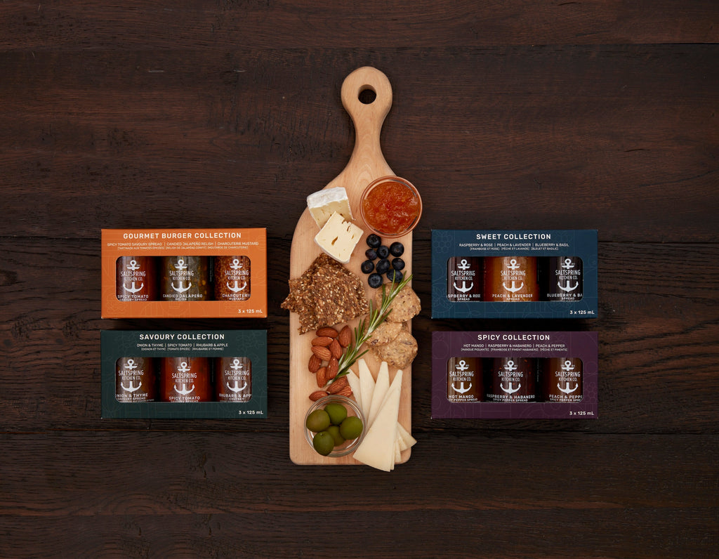 SaltSpring Kitchen Company Jam Packed Bundle sets of collection boxes with three jars or bottles inside stacked on a table with a greeting card