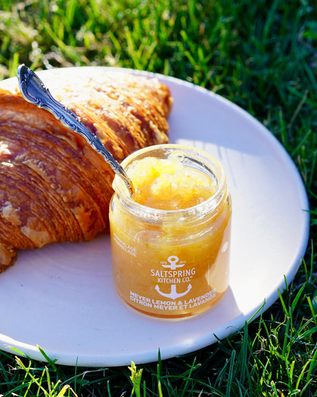 Meyer Lemon and Lavender Marmalade on a white plate outdoors with a croissant