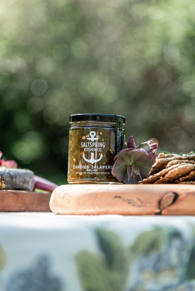 Jar of SaltSpring Kitchen Company Candied Jalapeño Relish on a wooden board outside
