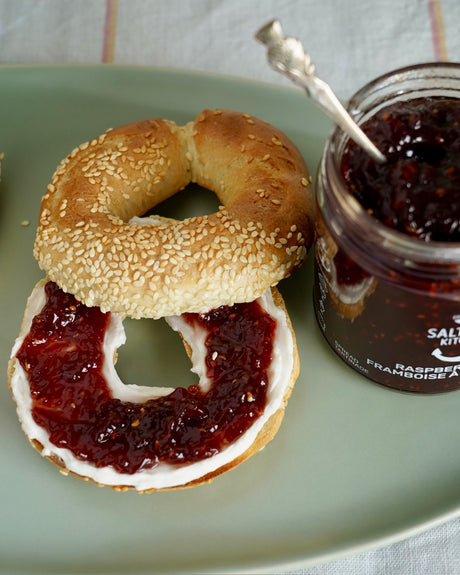 SaltSpring Kitchen Company Raspberry and Rose Spread on a bagel with cream cheese on a tray