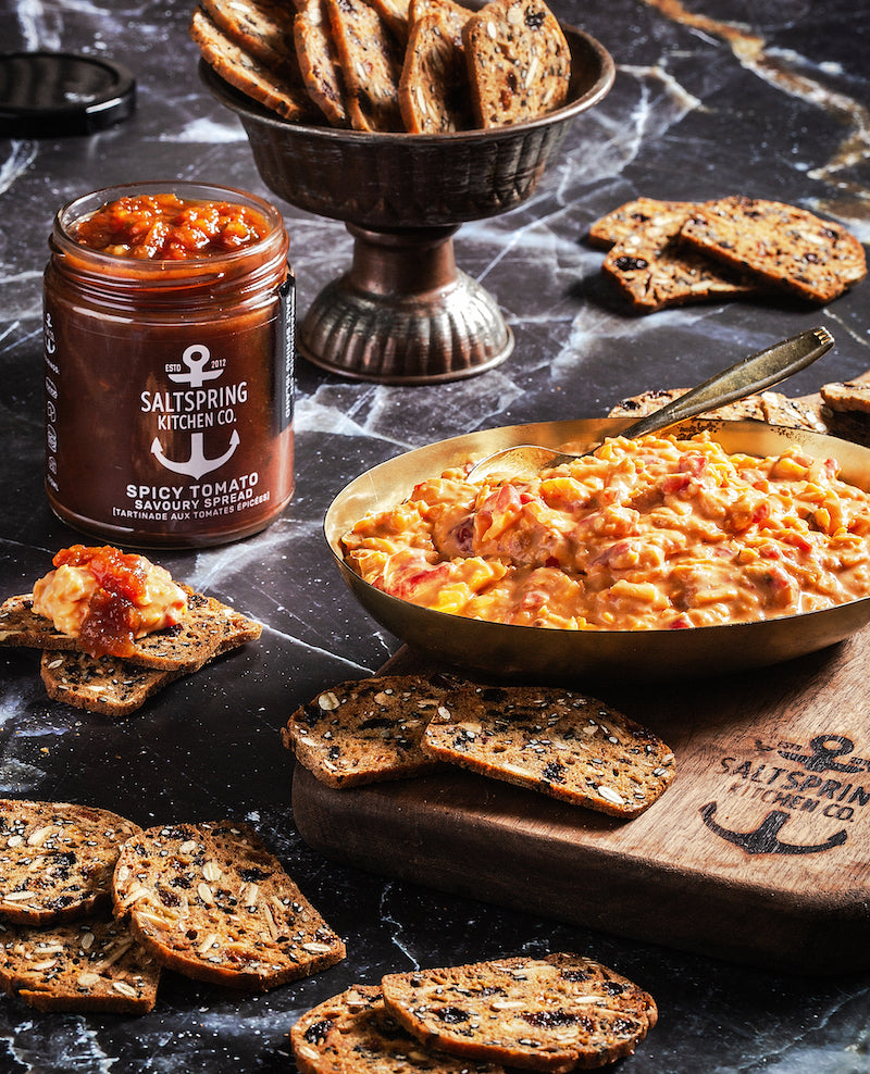 SaltSpring Kitchen Company Spicy Tomato Pimento Cheese Dip with Spicy Tomato Savoury Spread and crackers on a serving board