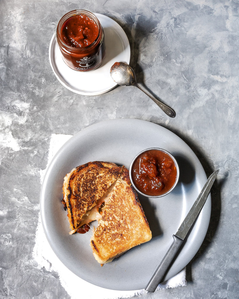 SaltSpring Kitchen Company Spicy Tomato Savoury Spread with a grilled cheese sandwich on a plate